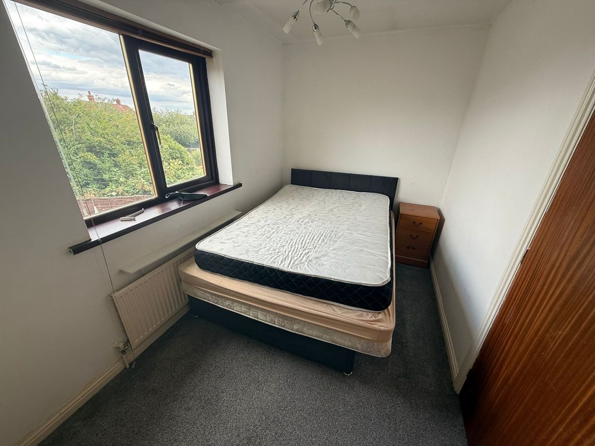 Bedroom before the end of tenancy clean, with old bed and mattresses left behind